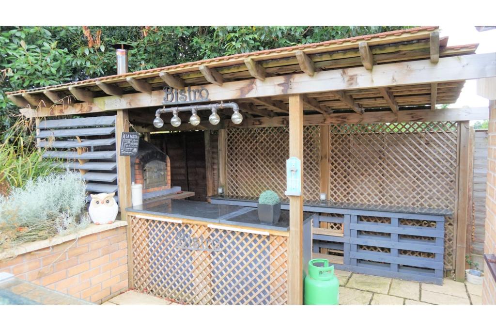Full outdoor kitchen with tiled roof and pizza oven fitted